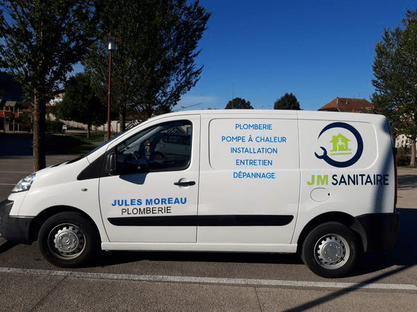 Camionnette de la société Jules Moreau Plomberie avec les services inscrits sur le côté, notamment plomberie, pompe à chaleur, installation, entretien, dépannage, et le logo JM Sanitaire.